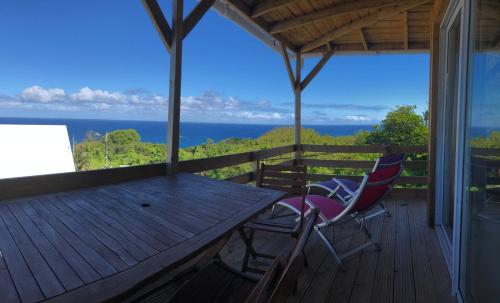 - une table et des chaises sur une terrasse avec vue sur l'océan dans l'établissement Alambic de Grand Anse, à Petite Île