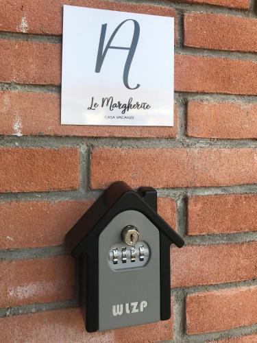 a mailbox on the side of a brick wall at Le Margherite in Cardano al Campo