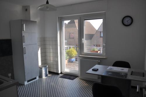 eine Küche mit einem Tisch und einem Fenster sowie einem Tisch und Stühlen in der Unterkunft Ferienwohnung Hölscher in Sendenhorst