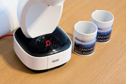 a white blender sitting on a table with two cups at Landhaus Amelinghausen Ferienzimmer in Amelinghausen