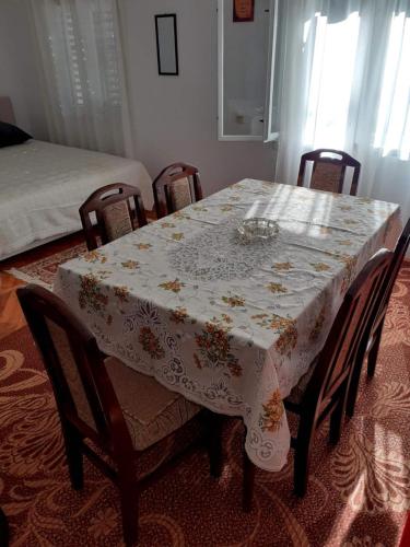 a dining room table with a flowered table cloth on it at Holiday Home Vladanka-Planinska kuća Vladanka in Biserske Kuće