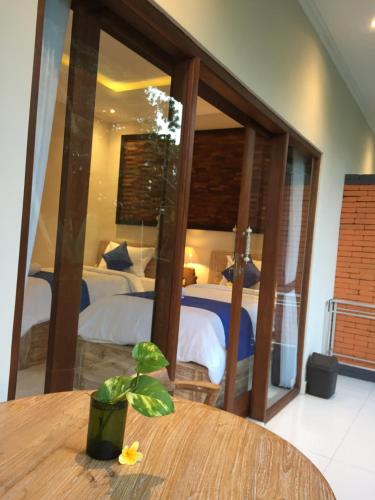a room with a bed and a table with a plant at Cahaya Guest House in Ubud
