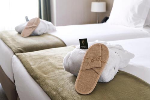 a pair of shoes sitting on top of two beds at The Leaf Boutique Hotel Lisbon in Lisbon