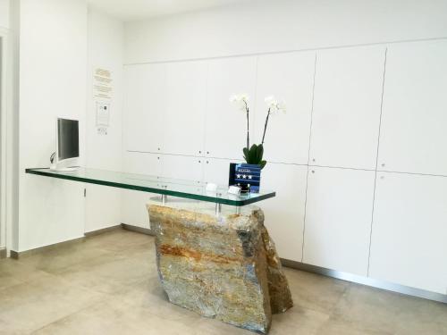 a glass table in a white room with a chair at Scorpios Hotel & Suites in Samos