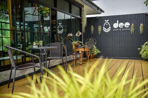 a patio with chairs and a table in front of a building at Dee Homestay in Ban Pa Khlok