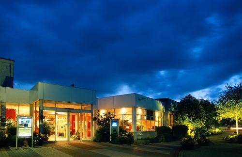 a large building with lights on at night at Novotel Coventry in Coventry
