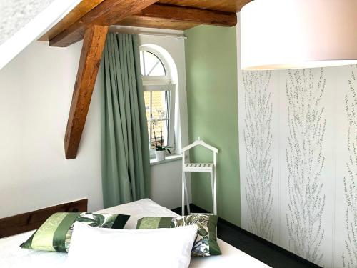 a bedroom with green walls and a window at Ferienapartments Spreewaldwiesen in Vetschau