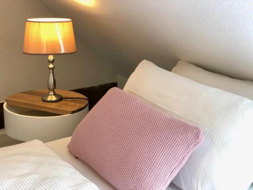 a bedroom with a bed with a pillow and a lamp at Ferienapartments Spreewaldwiesen in Vetschau