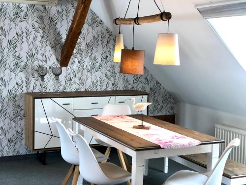 a dining room with a table and white chairs at Ferienapartments Spreewaldwiesen in Vetschau