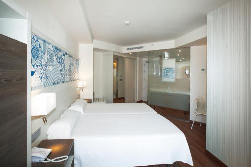 a hotel room with a white bed and white walls at Port Benidorm Hotel & Spa 4* Sup in Benidorm