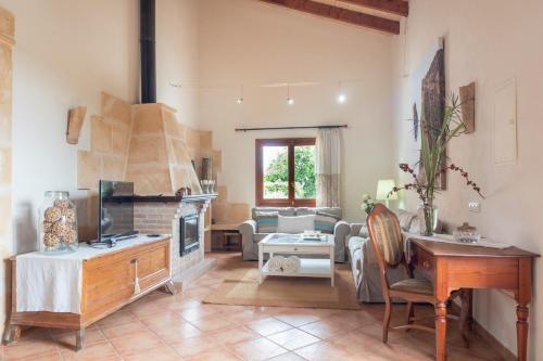 a living room with a fireplace and a table at Finca CARRITX in Can Picafort