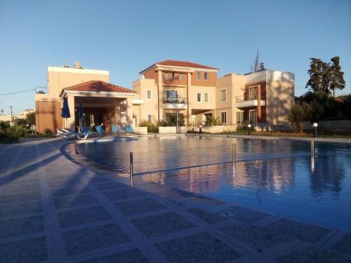 duży basen przed niektórymi budynkami w obiekcie Golden Victory w mieście Agia Marina Nea Kydonias