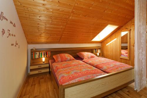フラウエナウにあるFerienwohnungen Clausの木製の部屋にベッド1台が備わるベッドルーム1室があります。