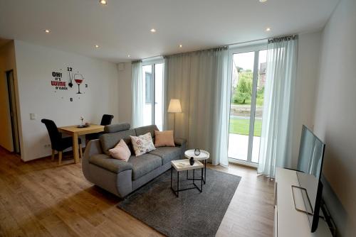 una sala de estar con un sofá y una mesa en NEU Mont Royal Suiten 2 bis 4 Personen, en Traben-Trarbach