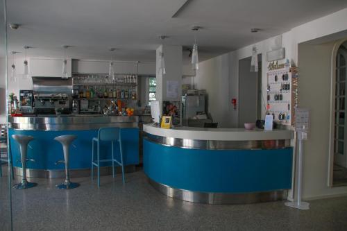 ベッラーリア・イジェア・マリーナにあるHotel Adriaの青いカウンターとスツール付きのレストランのバー