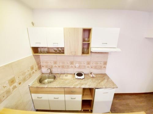 MAGENTA Apartments في بلغراد: مطبخ مع حوض ودواليب بيضاء