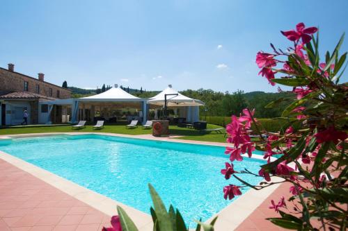 una piscina en un patio con flores en Poggio Paradiso Resort & Spa en Montefollonico