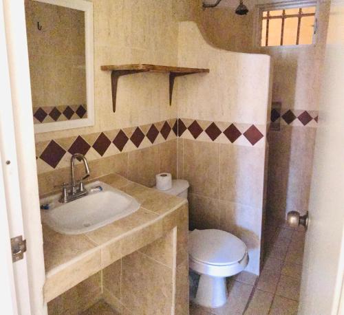 a bathroom with a sink and a toilet at Bungalows El Rincon de La Riviera in Rincon de Guayabitos