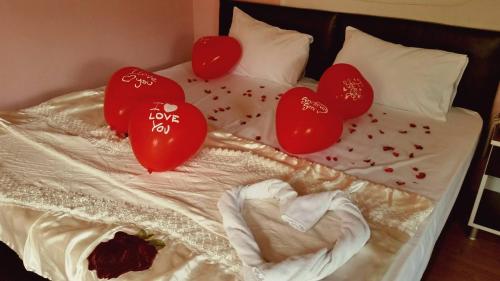 uma cama com corações de namorados em Konak Hotel Tuzla em Tuzla