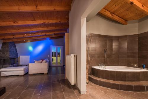 a large bathroom with a tub and a couch at Muthee Luxurious Private Villa in Laganas