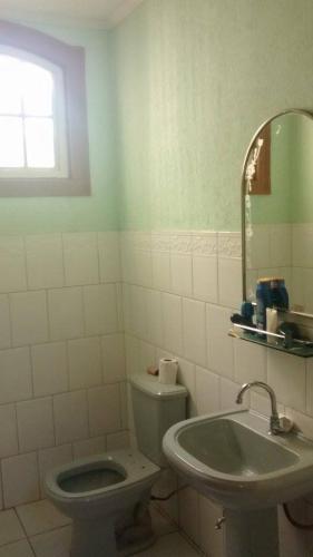 a bathroom with a toilet and a sink at Casarão do DU in Campinas