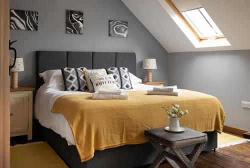 1 dormitorio con 1 cama grande con manta amarilla en Finest Retreats - Berry Cottage - 4 Bedroom, Pet-Friendly Cottage Sleeping 8, en Eglwyswrw