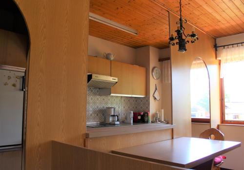 a kitchen with a wooden ceiling and a table at Haus Bergquell in Ramsau am Dachstein