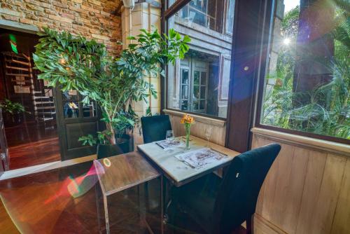 a table and chairs in a room with plants at Factoria Hotel in Asuncion