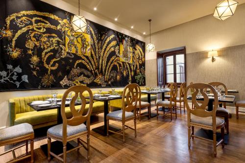 a dining room with a large painting on the wall at Pousada Palacio de Estoi – Small Luxury Hotels of the World in Estói