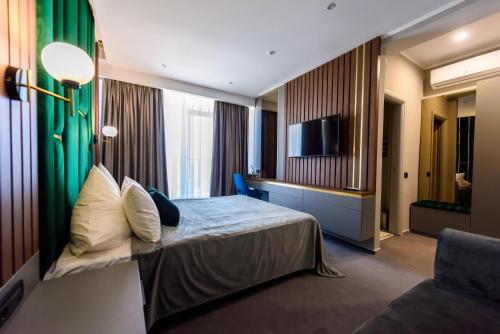 a hotel room with a bed and a television at Vila Time Olimp in Olimp