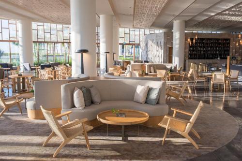 a lobby with a couch and chairs and tables at Alma Resort Cam Ranh in Cam Ranh