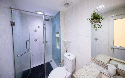 a bathroom with a toilet and a glass shower at Sunny Hotel in Hanoi
