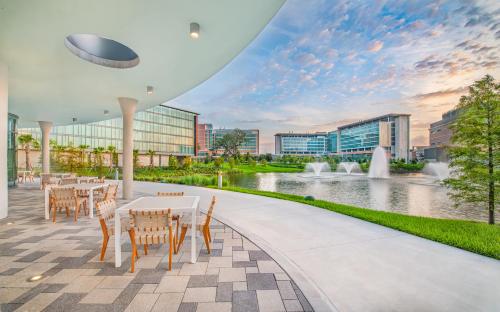 a patio with tables and chairs and a fountain at Hotel Eleo at the University of Florida in Gainesville