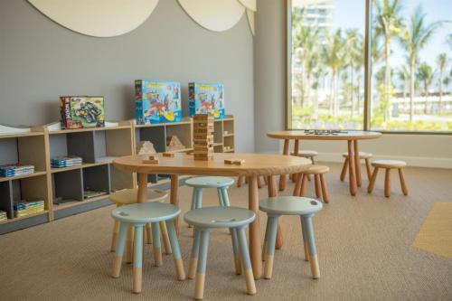 a classroom with two tables and stools and a table and chairs at Alma Resort Cam Ranh in Cam Ranh