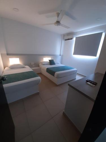 a room with two beds and a table in it at Apartahotel y Hotel Sofichic Boutique in Barranquilla