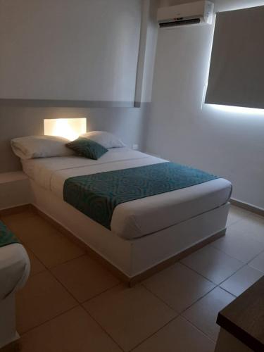 a bedroom with a bed with a light on it at Apartahotel y Hotel Sofichic Boutique in Barranquilla