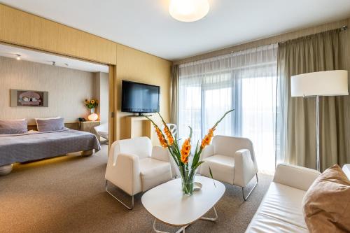 a hotel room with a bed and a living room at Niebieski Art Hotel & Spa in Krakow
