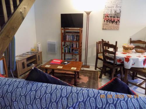 un salon avec une table et une salle à manger dans l'établissement Aux Roses, à Vrolle