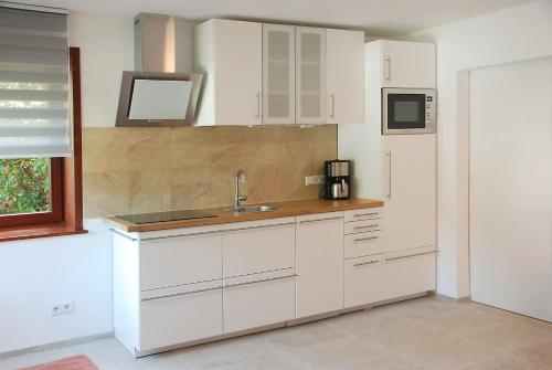 a kitchen with white cabinets and a sink at Wo das Ruhrgebiet am schönsten ist in Hattingen