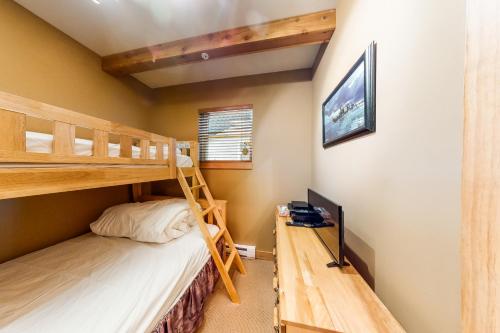 a bedroom with two bunk beds and a desk at Timber Ridge in Big White