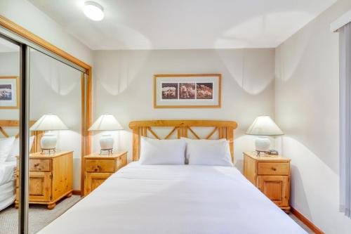 1 dormitorio con 1 cama grande y 2 lámparas en Lagoons at Stoney Creek, en Whistler