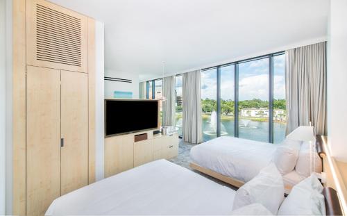 Habitación de hotel con 2 camas y TV de pantalla plana. en Hotel Eleo at the University of Florida, en Gainesville