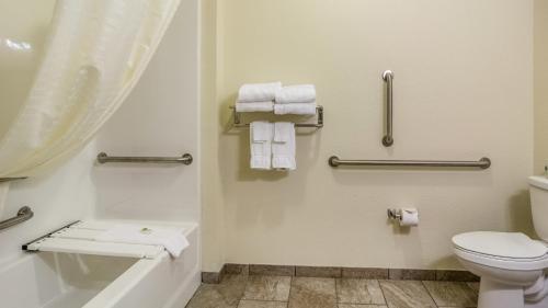 a bathroom with a toilet and a sink and towels at Cobblestone Inn & Suites - Vinton, LA in Vinton
