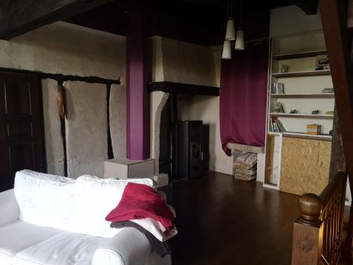 a bedroom with a white bed with a red pillow at Maison atypique à Cordes-Sur-Ciel 2 chambres in Cordes-sur-Ciel