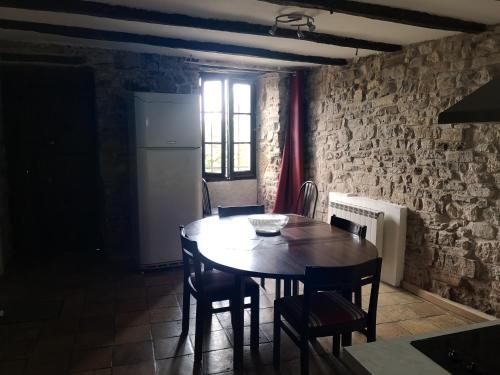uma sala de jantar com mesa e cadeiras e uma parede de tijolos em Maison atypique à Cordes-Sur-Ciel 2 chambres em Cordes-sur-Ciel
