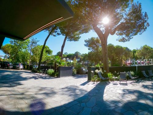a sun shining through a tree in a park at Hotel Costa Verde in Milano Marittima