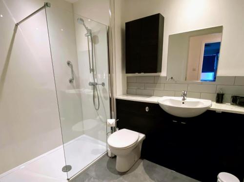 a bathroom with a shower and a toilet and a sink at The Lochend Residence in Edinburgh
