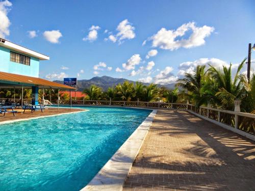 una piscina en un complejo con montañas en el fondo en Hotel Viña del Mar Omoa, en Omoa