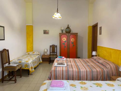 a room with two beds and a table and chairs at Bed and Breakfast da Antonio - Orgosolo in Orgosolo