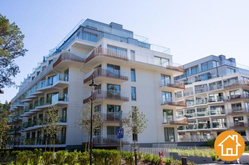 an apartment building with a sign in front of it at Apartamenty ApartPark - visitopl in Świnoujście